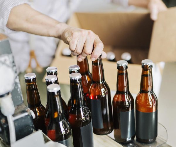 brewery-worker-preparing-beer-bottles-U498MD9